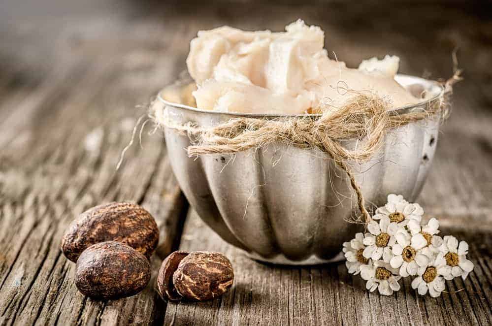 Raw shea butter with fatty acids in a bowl that can be used for an irritated scalp, restorative mask, and frizz-free curls