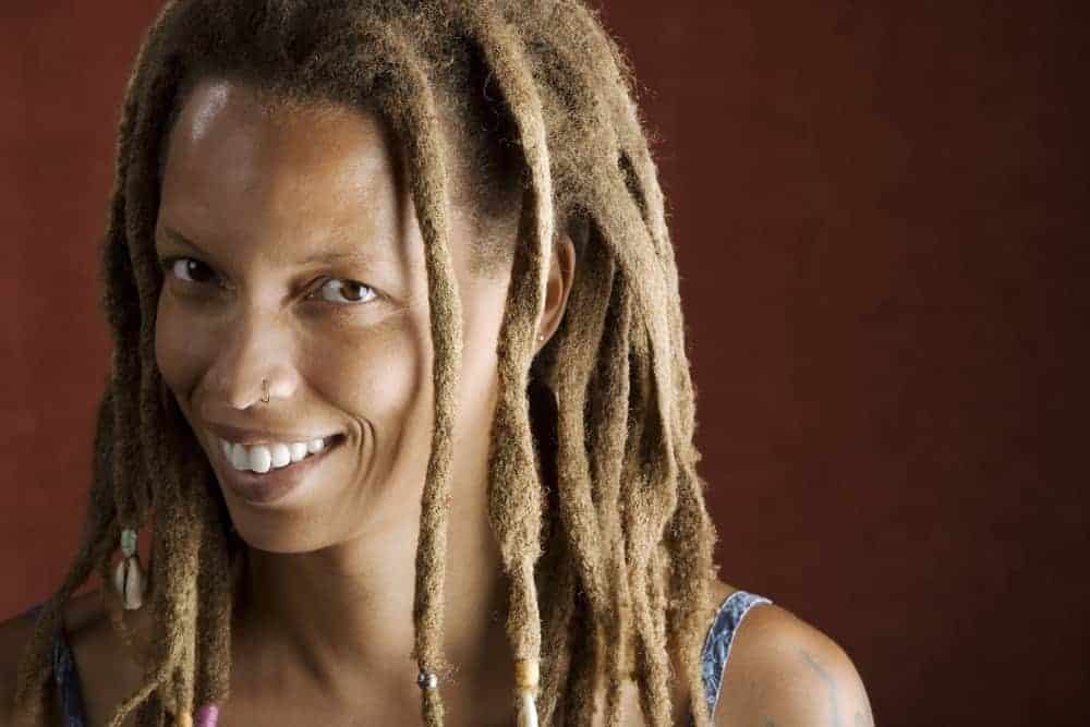 Middle-aged black woman with naturally wavy hair wearing dreadlocks with natural face-framing layers.