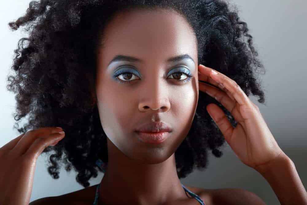 Cute black girl wearing blue eye shadow with low porosity hair strands