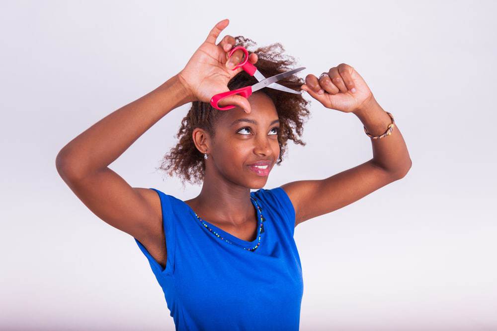 Young African American women cutting her hair