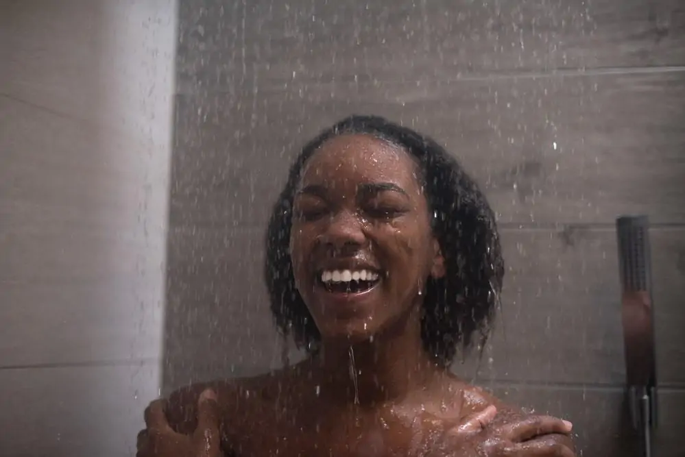 How to Pre-Poo Curly Hair With Olive, Coconut Oil, and More 2 A lady woman using a clarifying shampoo during her wash day routine.