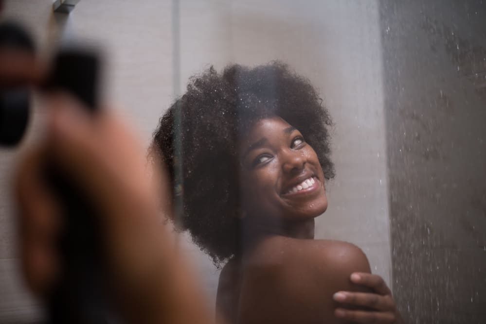 A lady with healthy hair has damp hair after a shower where she used a pre-poo recipe on her fine hair strands.