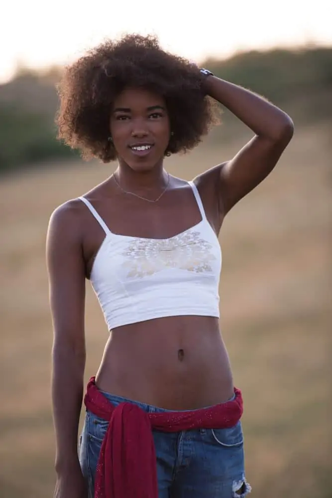 How to Pre-Poo Curly Hair With Olive, Coconut Oil, and More 4 African American female with damaged hair after having her hair follicles exposed to heated styling tools.