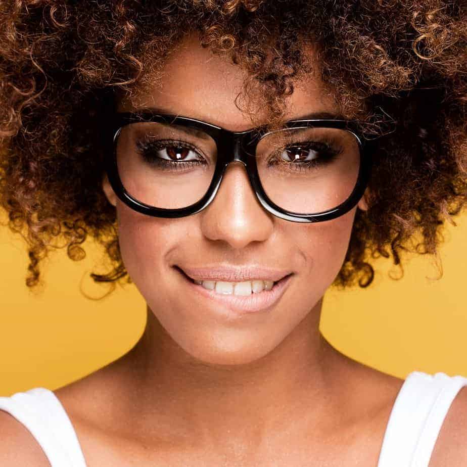 A young black girl dried her wet hair with a blow dryer after shampoo and deep conditioning treatments.