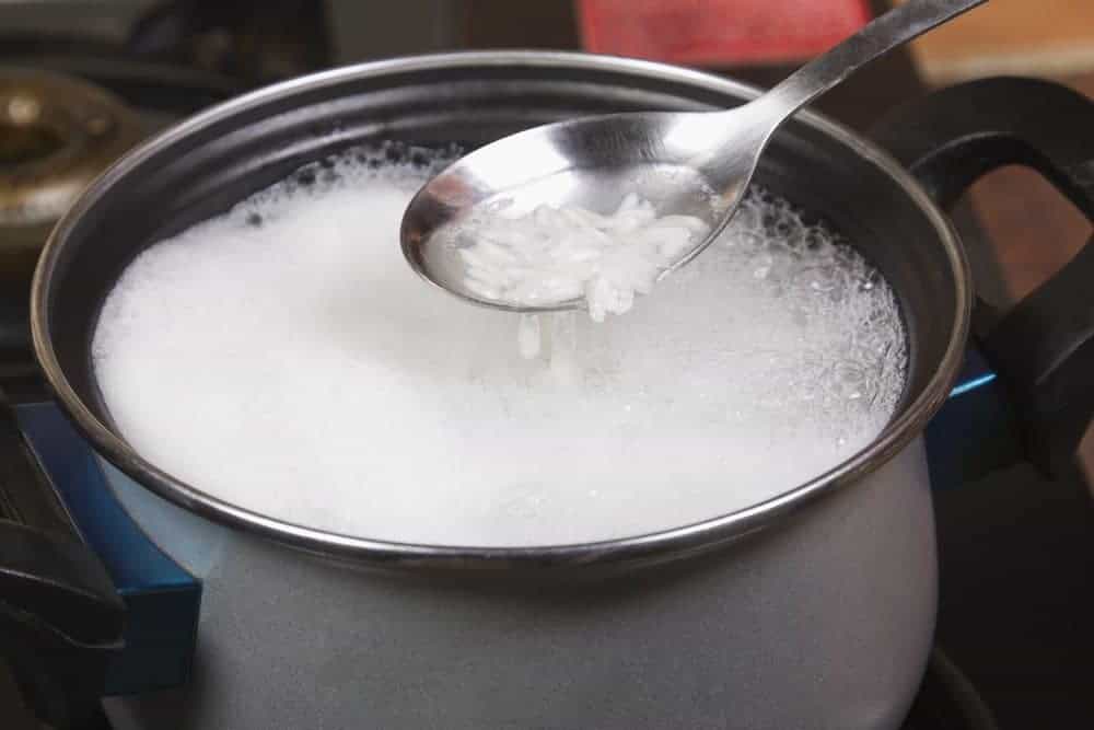 A lady embracing the rice water trend by making a rice water shampoo to wash hair.