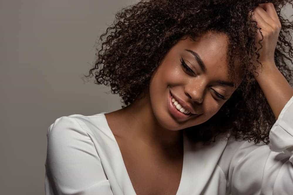 A cute black girl with curly hair treated with rice water protein hair care products.