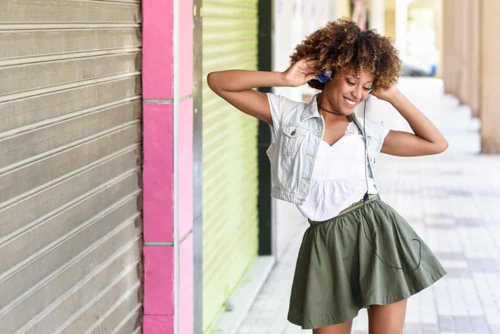 An African American female wearing bouncy curls in a wash-and-go hairstyle styled with CG-approved hair products.