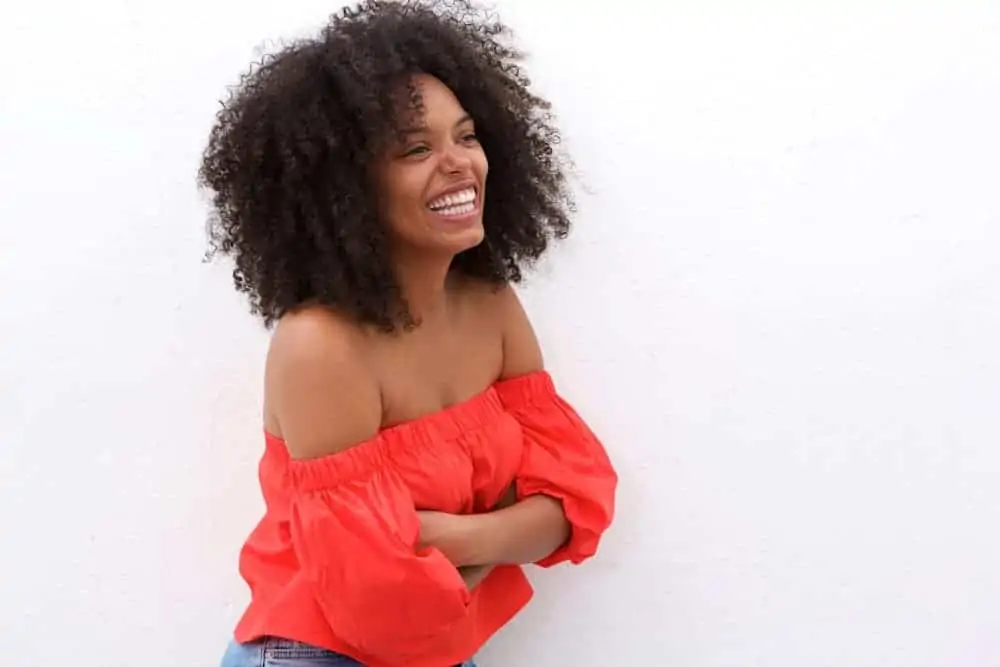A black girl uses a scalp massage device for increased hair thickness and to reduce hair loss.