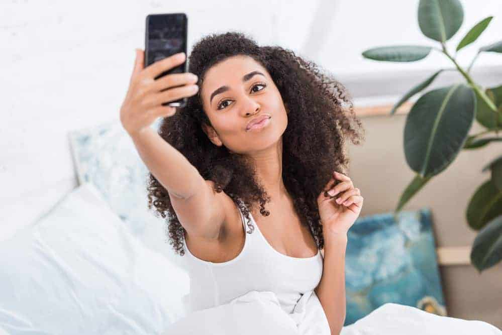 African American women taking a picture of herself after reading the do's and don'ts of the Curly Girl Method