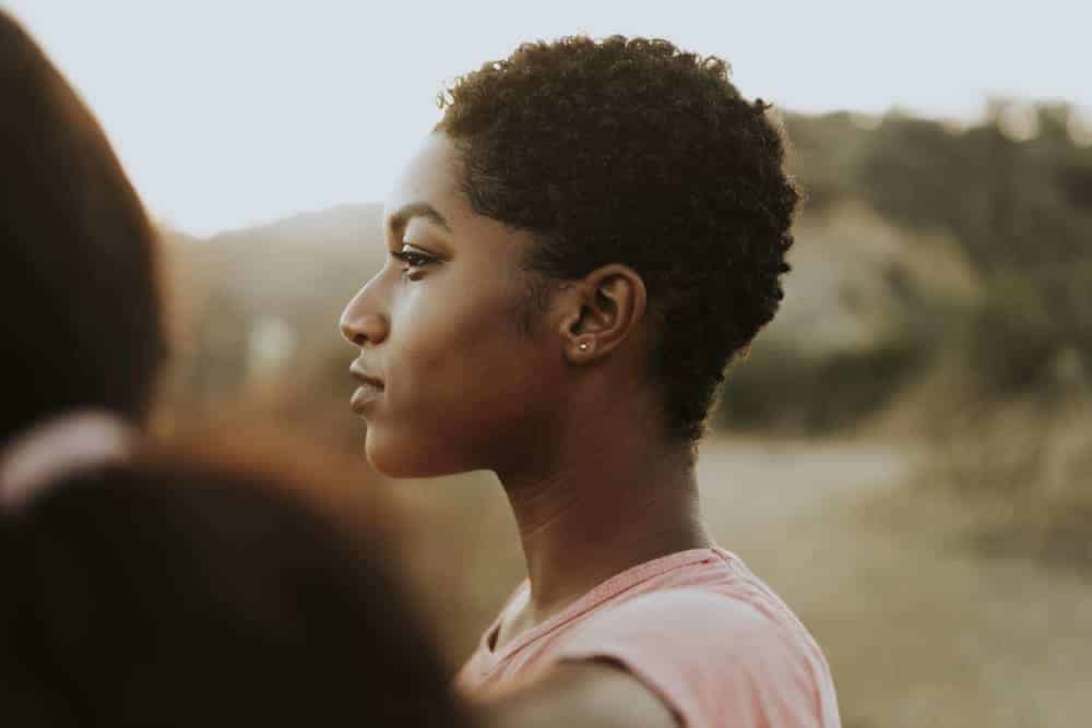 Cute dark-skinned black girl with defined curls after using a sponge to gently rub her curls in the same direction.