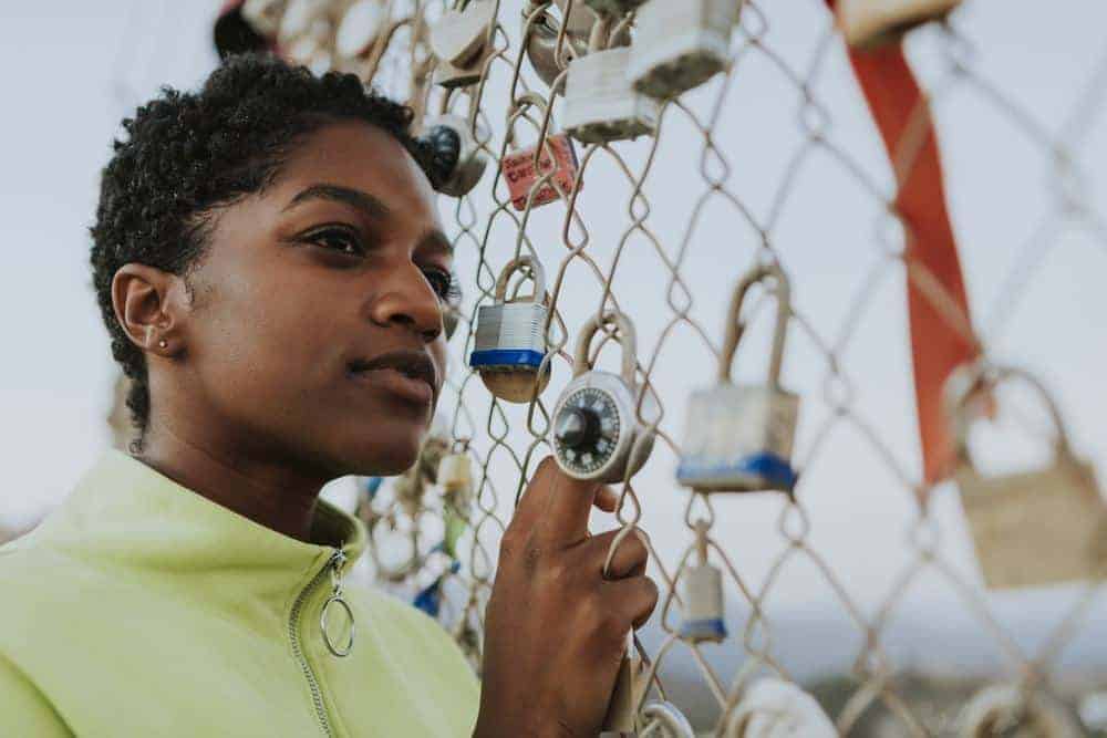 The Best Hair Sponge: Creating the Curl Definition for Short Natural Hair 6 Cute black girl standing outside in front of a fence with padlocks.