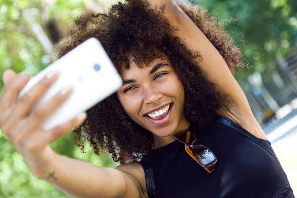 A light-skinned black lady with dry hair used a few drops of warm grapeseed oil to promote healthy hair growth.