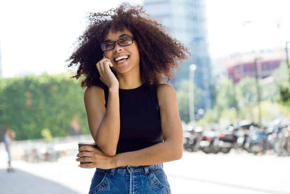 An African lady with coarse hair strands styled with a DIY hair mask created with almond oil and lavender essential oil.