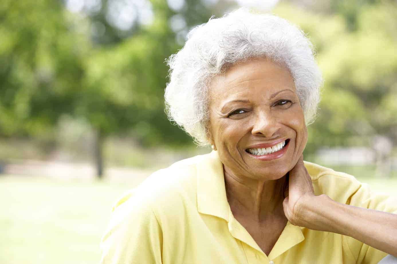 Older black women smiling at the park. 