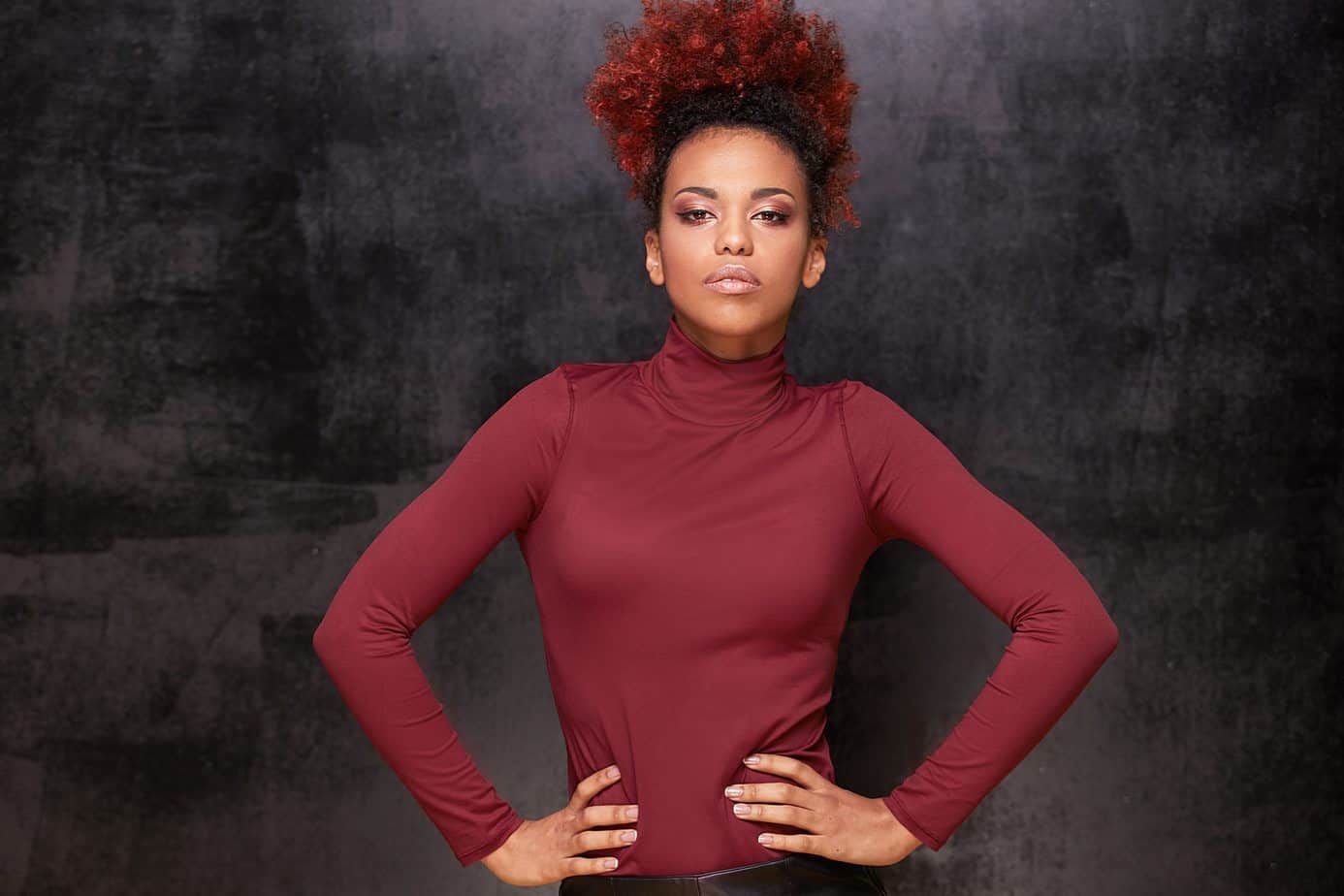 Young lady showing that hair dyeing hair treatments are art with her black and red two-toned hairdo.