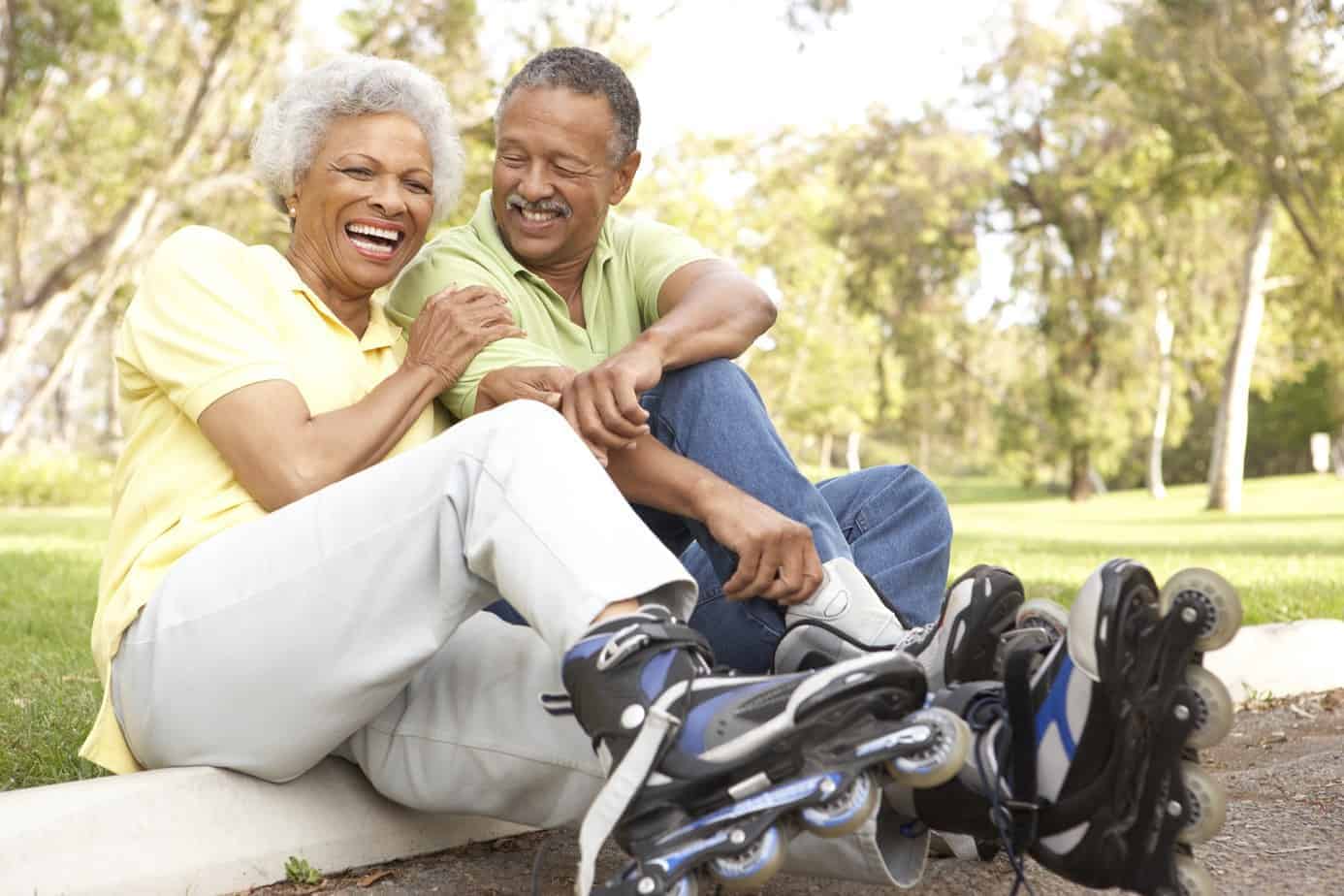 Black couple sitting the curb after in line skating. 