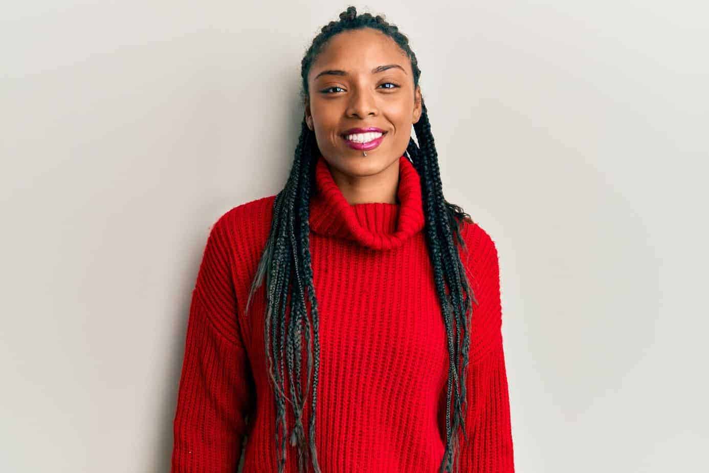 Beautiful African American female wearing blue yarn braids on a white background.