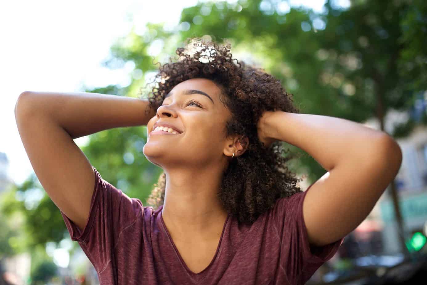 Pretty black girl with curly hair looking into the distance.