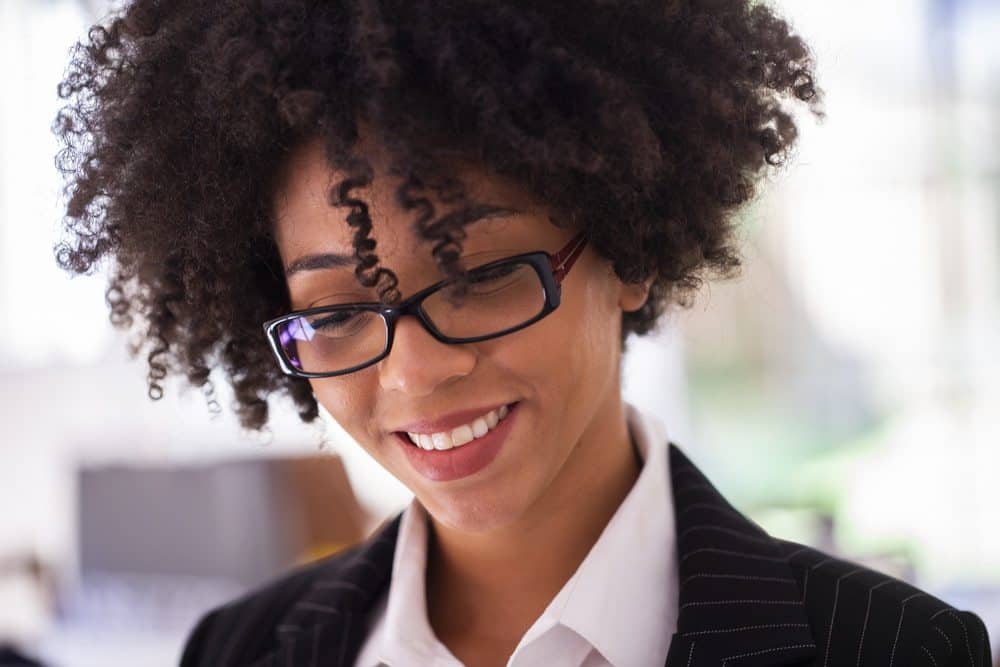 Successful young African American businesswoman looking focused while working on a digital tablet in her home office.