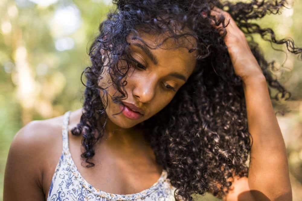 Young black girl with natural curls after using a few drops of clary sage essential oil for thicker and stronger hair.