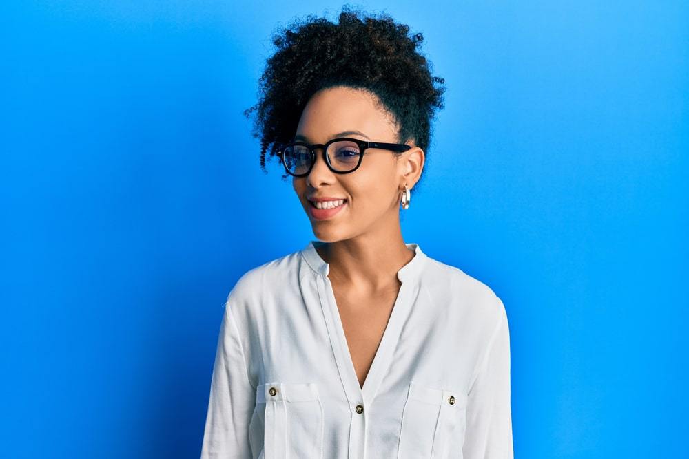 Cute young African American female after using a carrier oil (jojoba oil) and shea butter oil to boost hair growth.