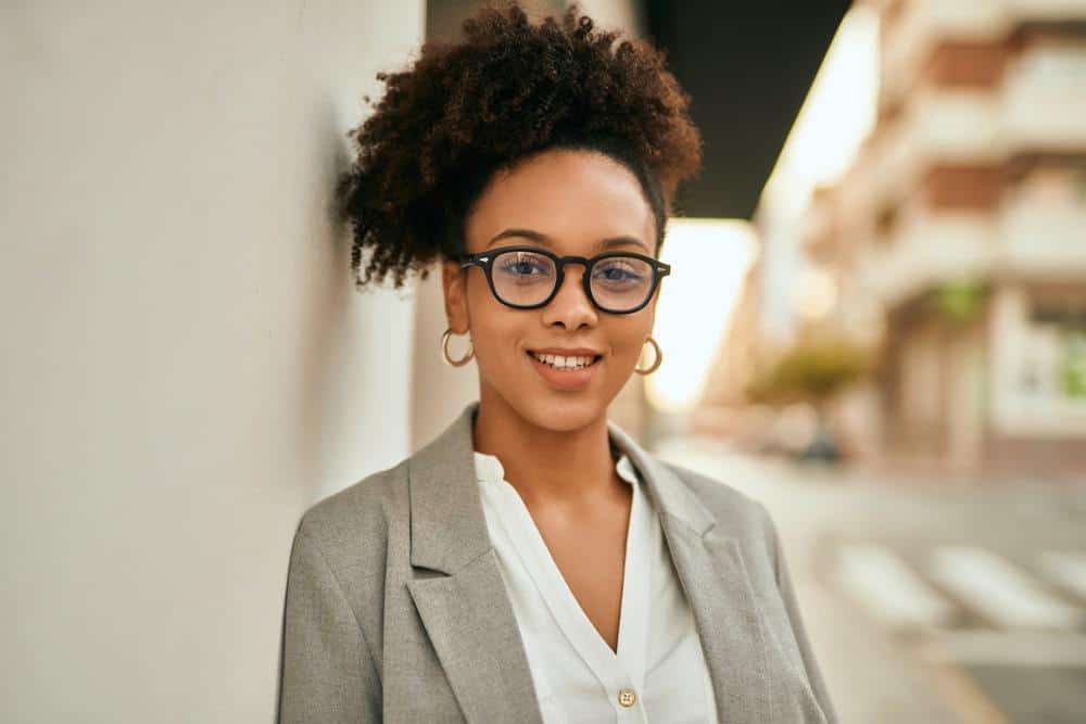 A young black with bouncy curls styled with her favorite scalp massage oil to encourage better blood circulation.