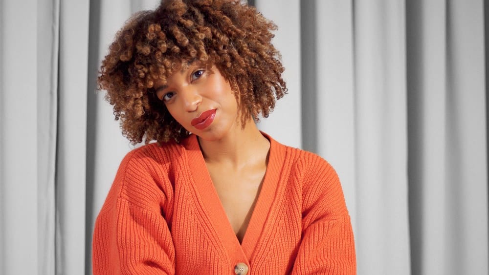 Closeup portrait of mixed race black woman after using a curling iron to achieve bouncy curls