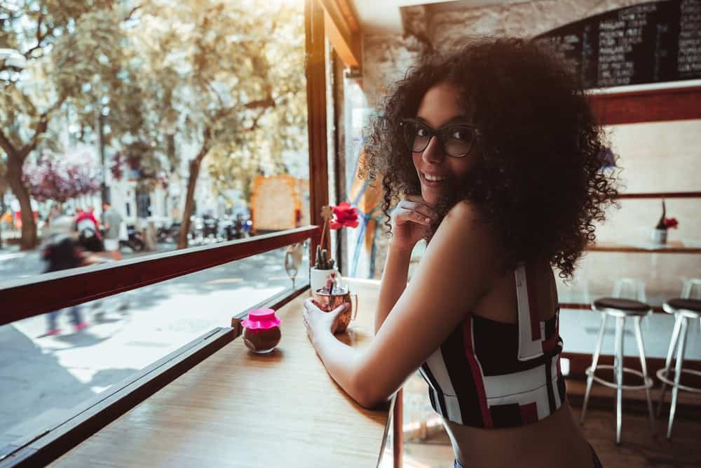 Cute mixed-race female with healthy hair after using essential oils for stimulating hair follicles and scalp irritation.