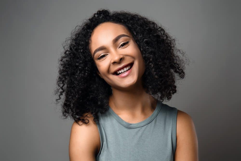 Cute black girl with dry hair styled with a few drops of pure baobab oil from the baobab tree for an itchy scalp.