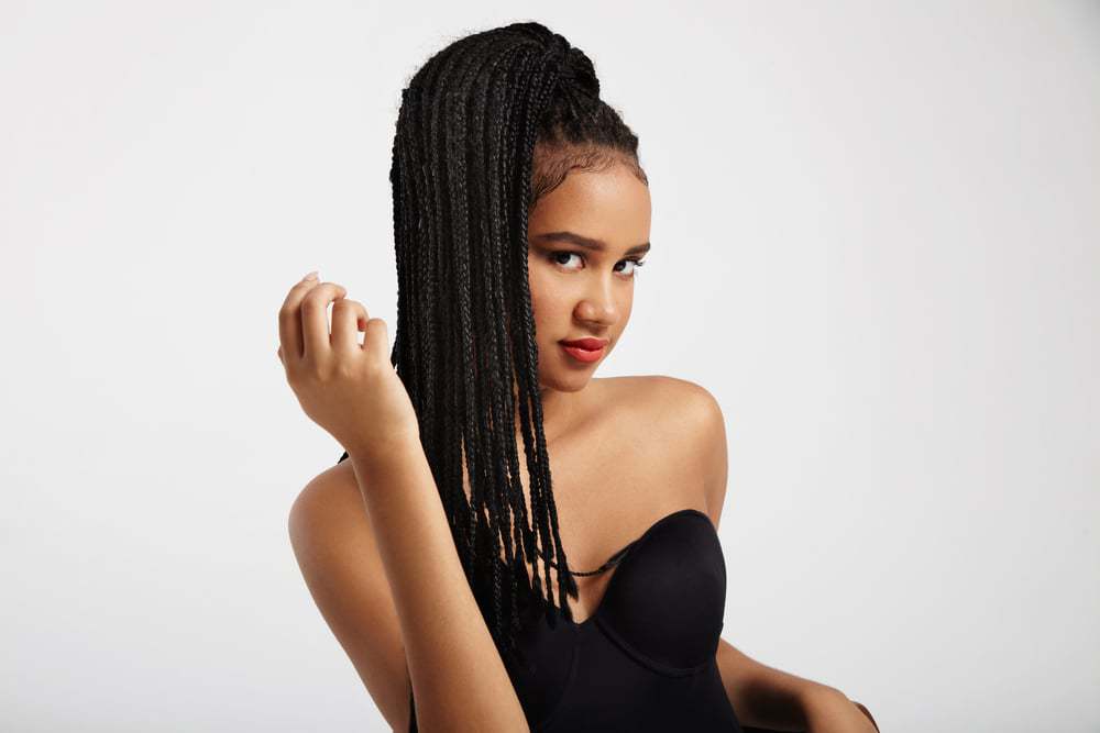 Black woman with wearing Janet Jackson braids on natural hair with a black dress.