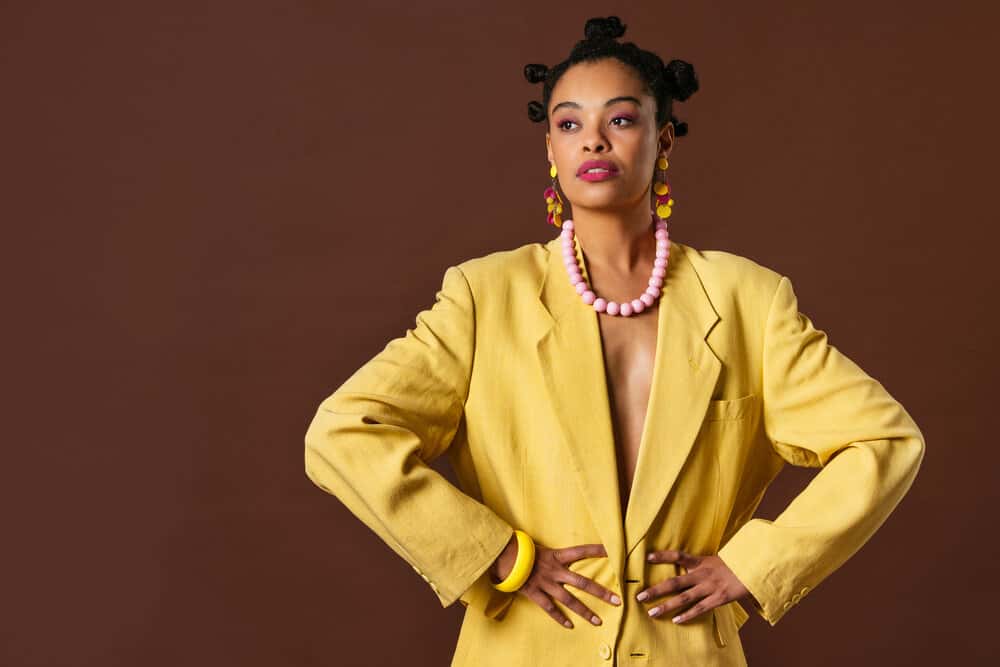 African American female with naturally fine hair wearing bantu knots created with a round brush.