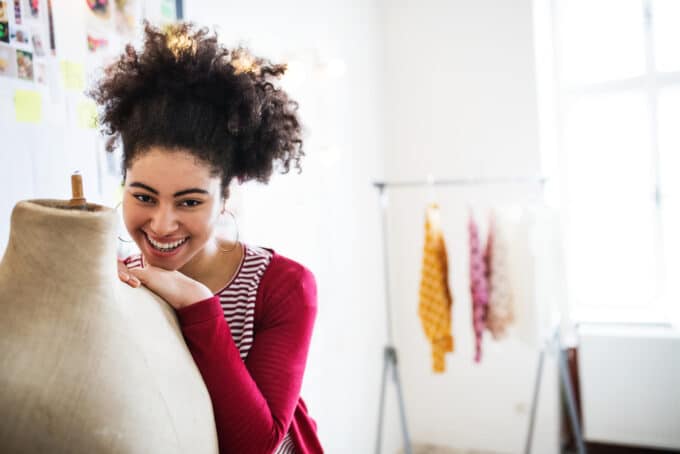 Black girl with a pineapple hairstyle with 4c curls, hoop earrings, and red shirt