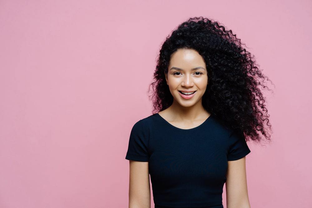 Light-skinned African American woman wearing a blue t-shirt styled with bergamot essential oils.