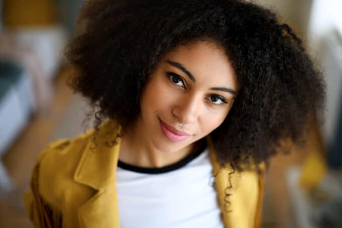 Cute black girl with curls treated with lemon oil for hair growth and other health benefits