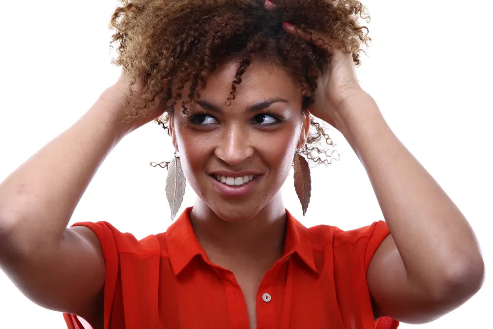 Pretty African American female wearing a red shirt with naturally curly hair. 