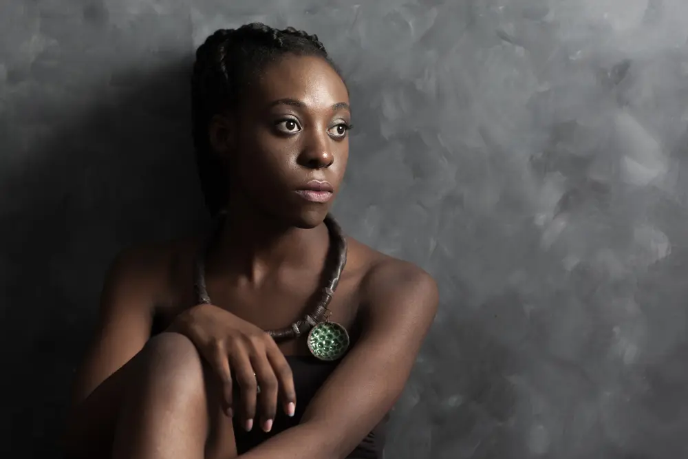 Ghana Braids: How to Do Ghanaian Cornrow Braid Hairstyles for Beginners 4 Black women in deep thought looking into the distance wearing a necklace.