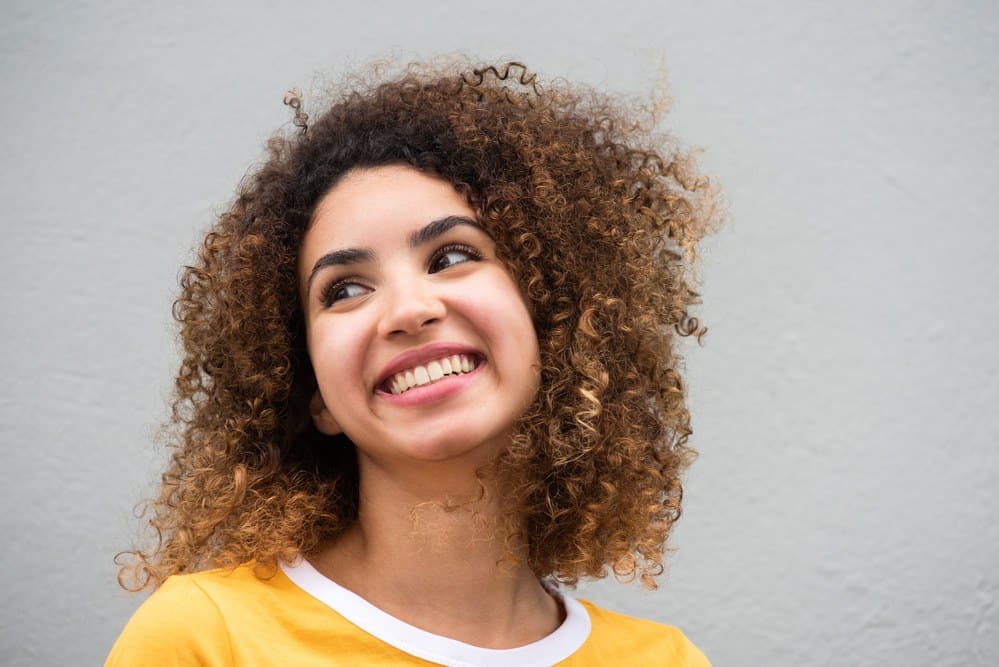 Beautiful black girl with low porosity hair after using the squish to condish technique.