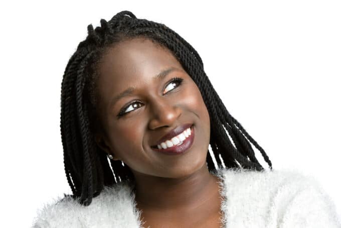 African American woman with braids wearing burgundy lipstick and silver earrings.