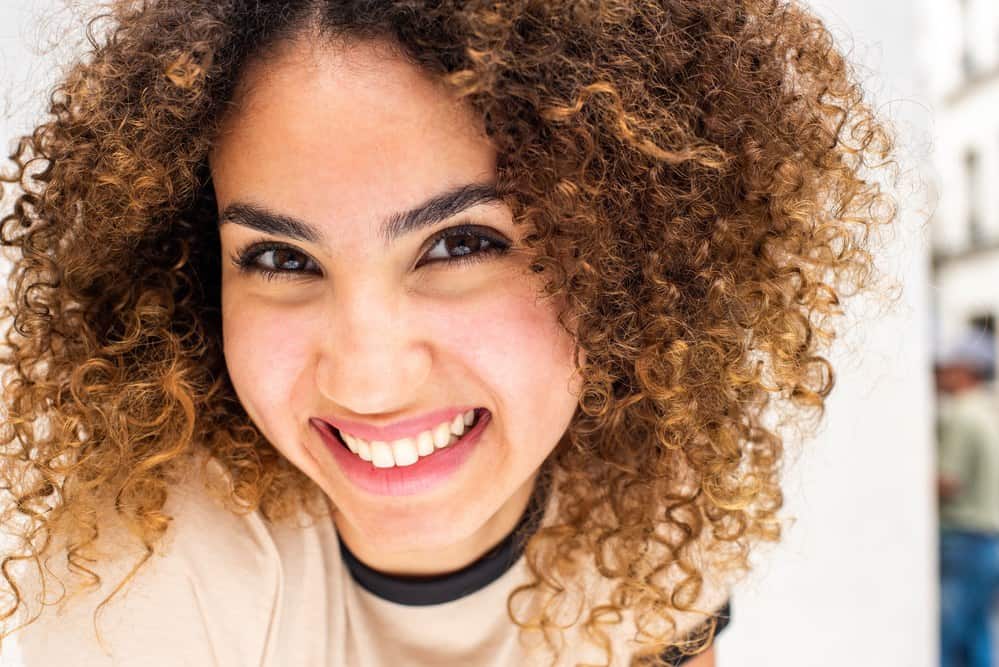 African American women smiling after learning how to her dry hair after the squish to condish technique.