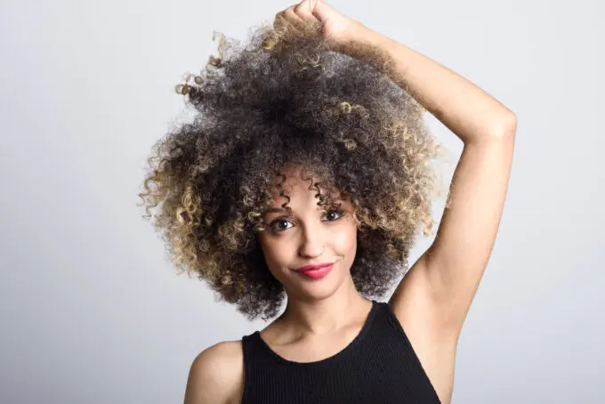 How To Dilute Hair Dye With Shampoo, Conditioner, Water, Pastel Colors, and More 5 Beautiful black girl with a huge curly hairstyle looking directly into the camera with a huge small.