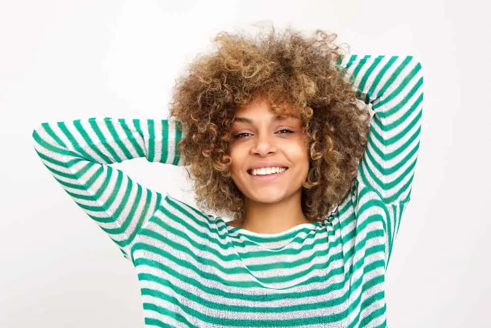 Using Dawn Dishwashing Soap for Hair Growth and Dandruff? Does It Work? 3 Black female with a green striped shirt feeling her hair after it's been washed with dish soap