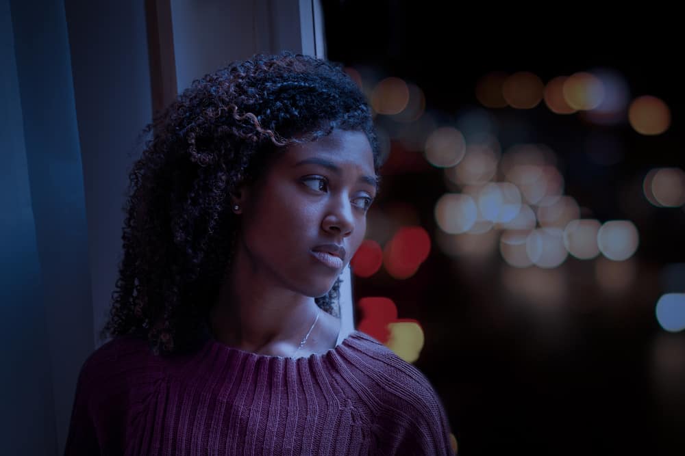 Sad female looking out of a window; looks like an advertisement or commercial for someone that's disappointed.