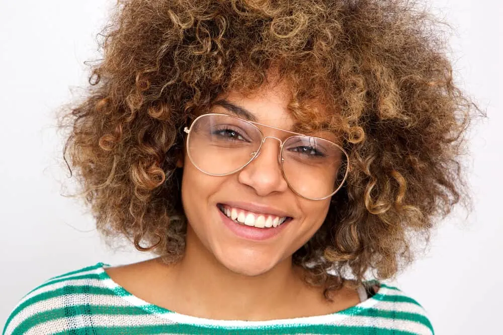 Using Dawn Dishwashing Soap for Hair Growth and Dandruff? Does It Work? 6 Black woman with a great smile with type 3 curly hair wearing glasses