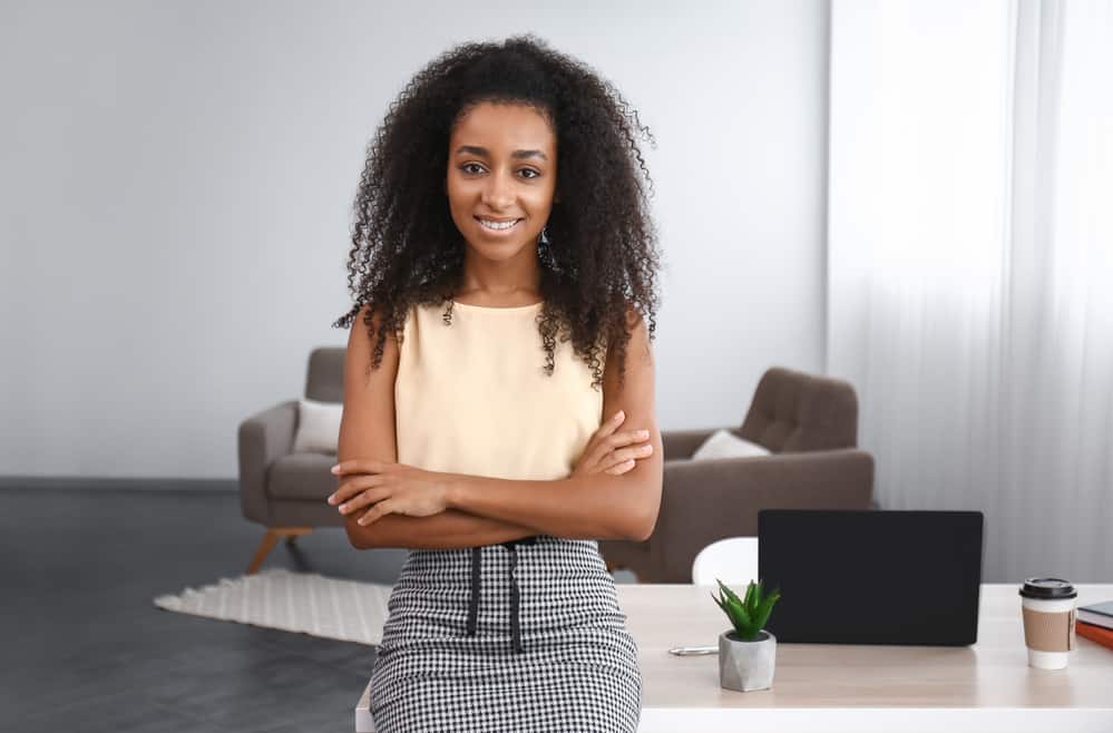 black women wearing a yellow dress shirt and a houndstooth skirt.