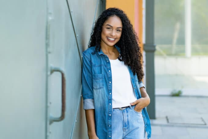 African American women wearing a blue jean outfit and a white t-shirt with type 3c natural hair.