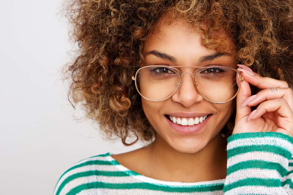 Cute African American female with curly hair that washes hair with Dawn dishwashing liquid to remove grease