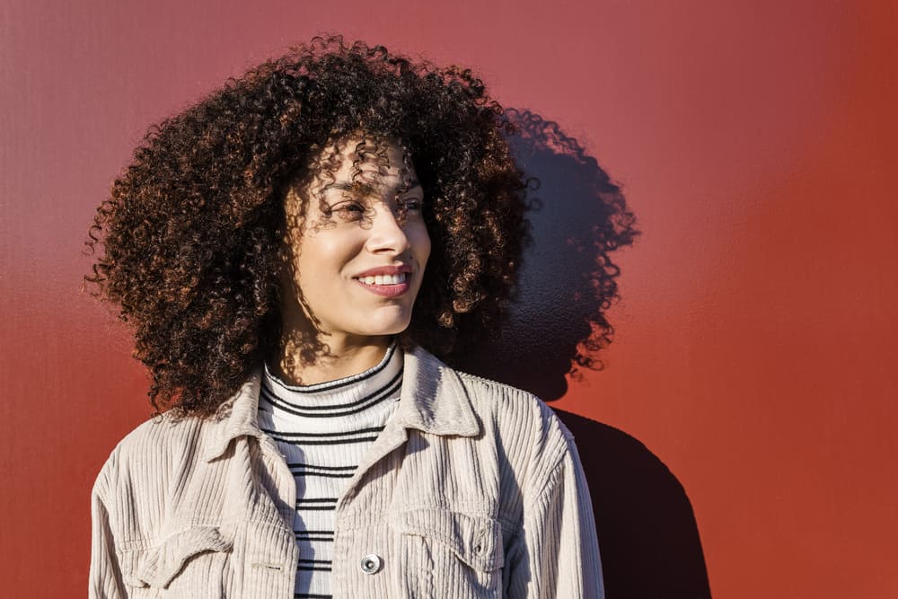 African American female with a big smile rocking a type 3a curly afro hairstyle.