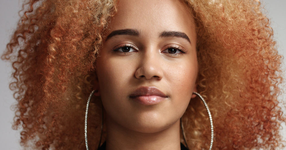 Confident black women with reddish-blonde hair and huge hoop earrings providing full shock value 