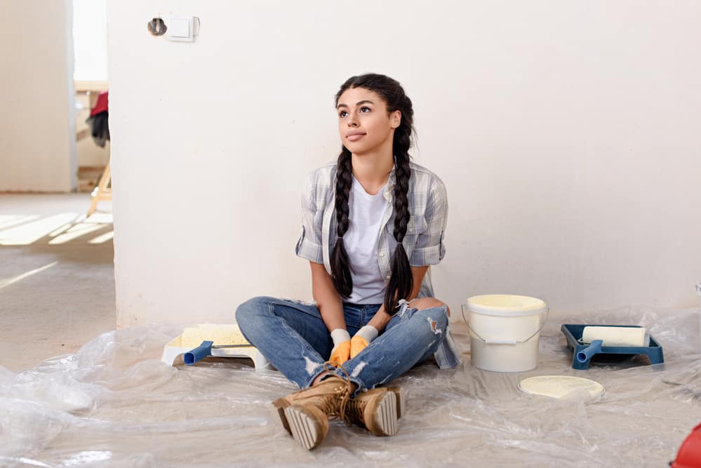 African American women sitting on the floor with wet hair that's stained with paint.