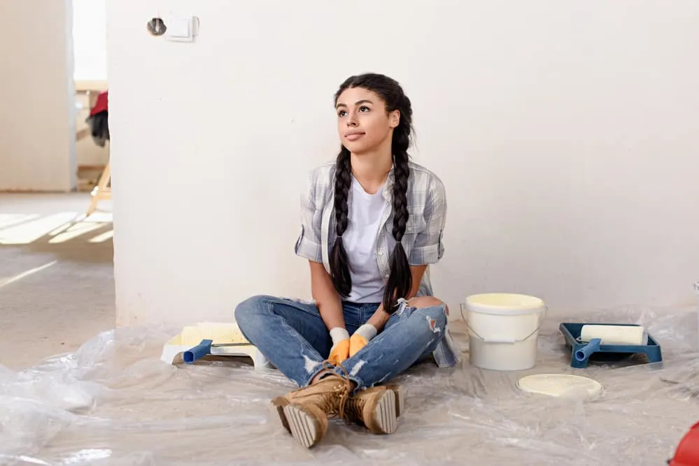 How To Get Paint Out of Hair: Easy Step-by-Step Solutions 2 African American women sitting on the floor with wet hair that's stained with paint.